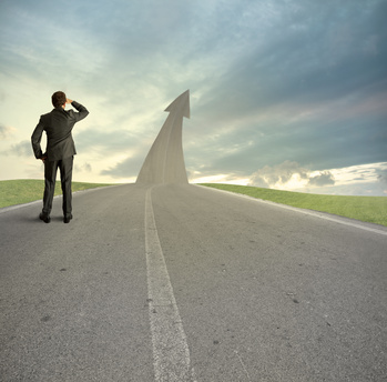 Die "road to success" ist lang. Ein Mann im Anzug blick in die Ferne.